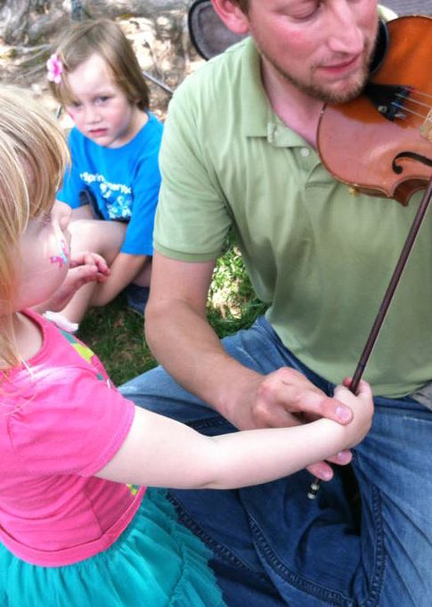 Man shows child how to play the fiddle fun things to do with kids in DC